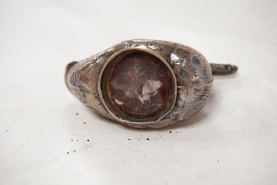 An Edwardian novelty silver mounted pin cushion, modelled as a duck, by Abrahall & Bint, engraved with 'feather' decoration and glass eyes, Birmingham, 1906, length 94mm, height 59mm(a.f.).